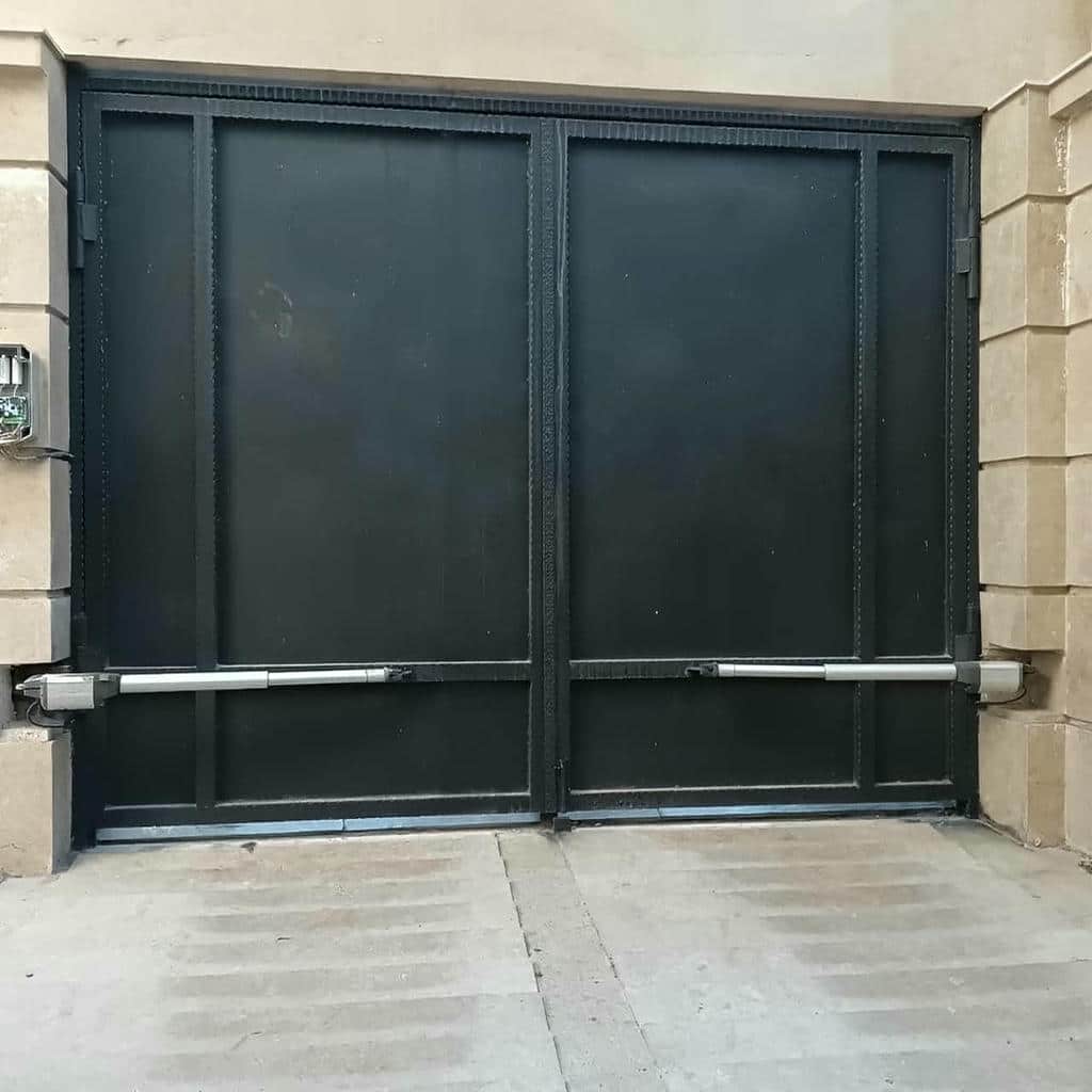 بازوی خاکستری دربازکن کنار لولای فلزی فرسوده