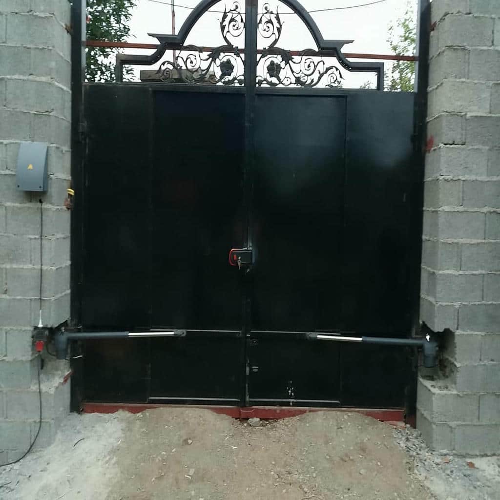 بازوی فلزی دربازکن اتوماتیک کنار ستون سیمانی