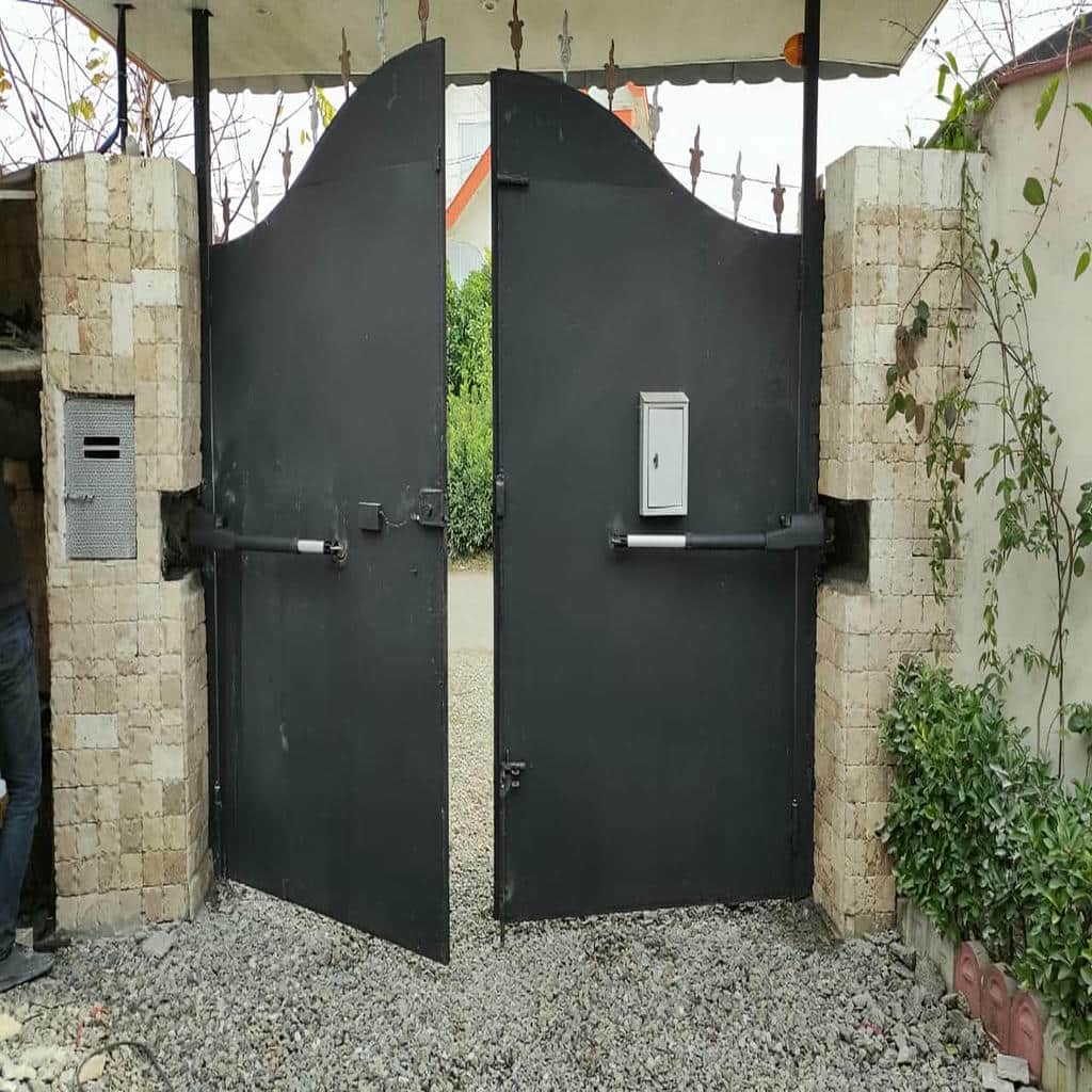 بازوی فلزی دربازکن کنار لنگه سنگین حیاط