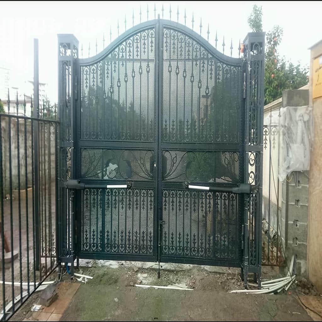 بازوی نقره‌ای موتور کنار لنگه فلزی حیاط