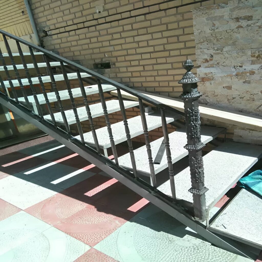 جان‌پناه آهنی خاکستری کنار پاگرد سنگی ساختمان