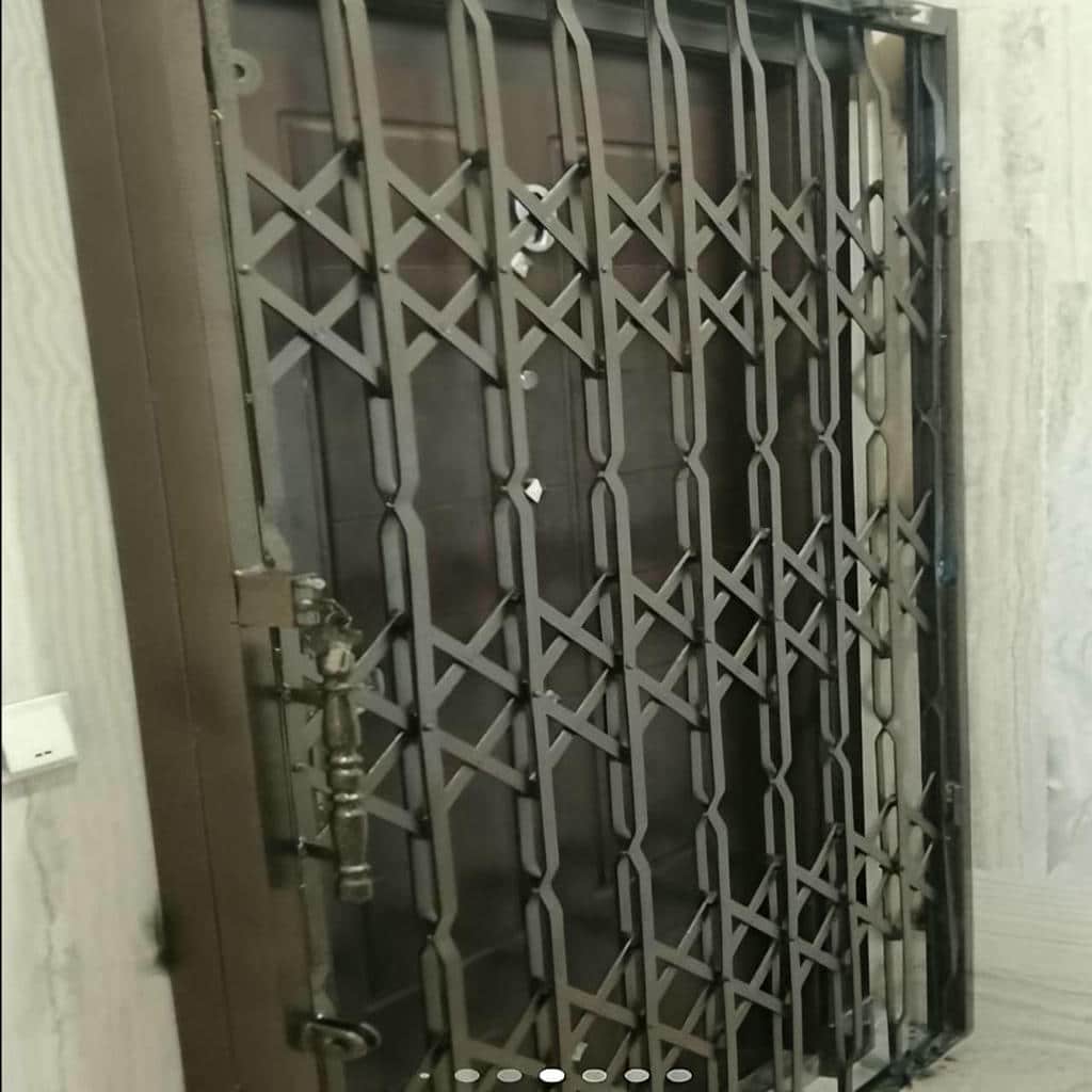حفاظ درب آکاردئونی جمع شده کنار چهارچوب ورودی