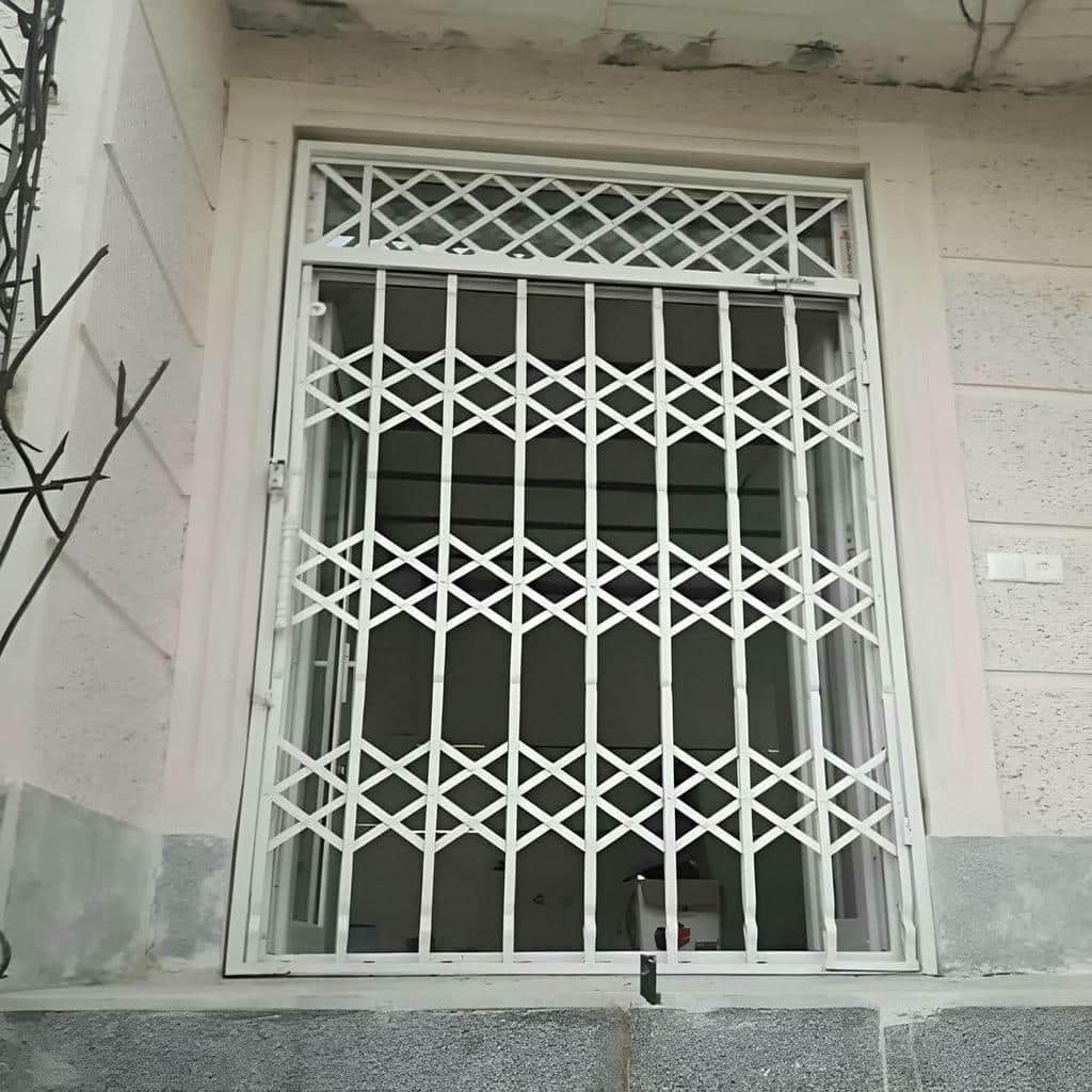 حفاظ درب آکاردئونی خاکستری کنار چهارچوب سنگی