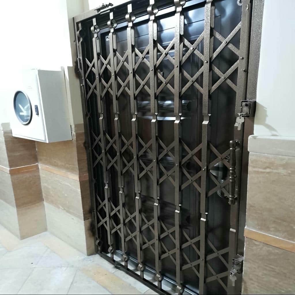 حفاظ درب آکاردئونی سفید در پاگرد باریک مسکونی