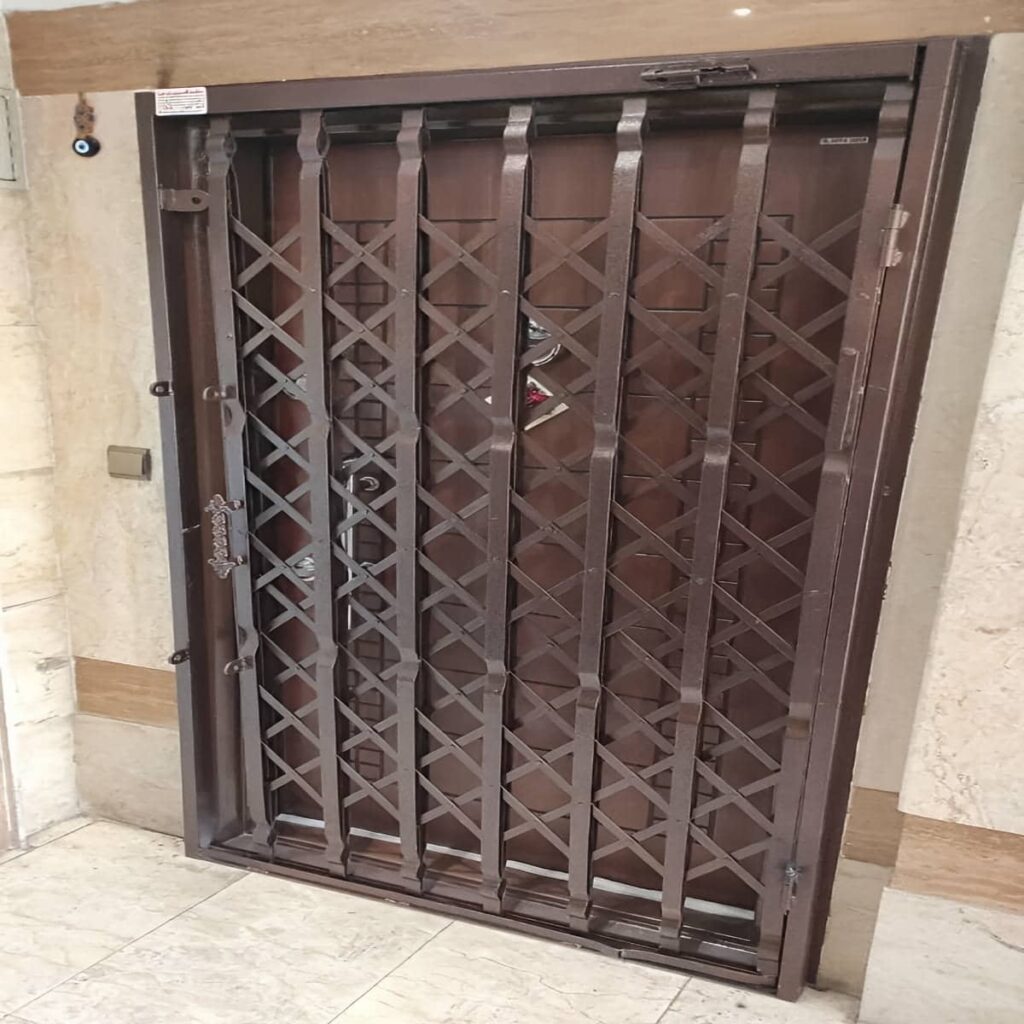 حفاظ درب آکاردئونی قهوه ای کنار چهارچوب در استان تهران