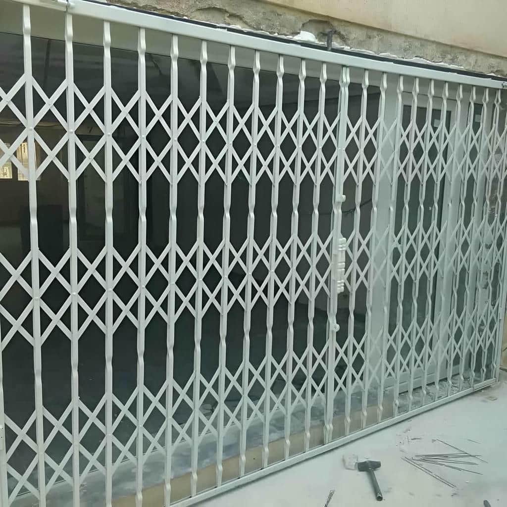 حفاظ درب آکاردئونی مشکی قفل دار مقابل واحد مسکونی تهران