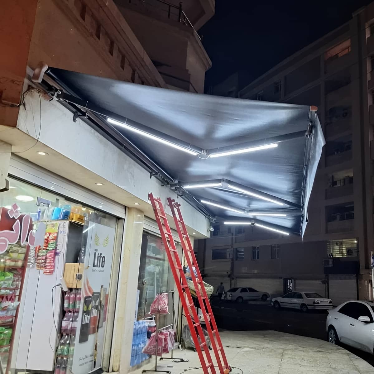 سایبان برقی طوسی بالای سردر سنگی قدیمی در ایلام