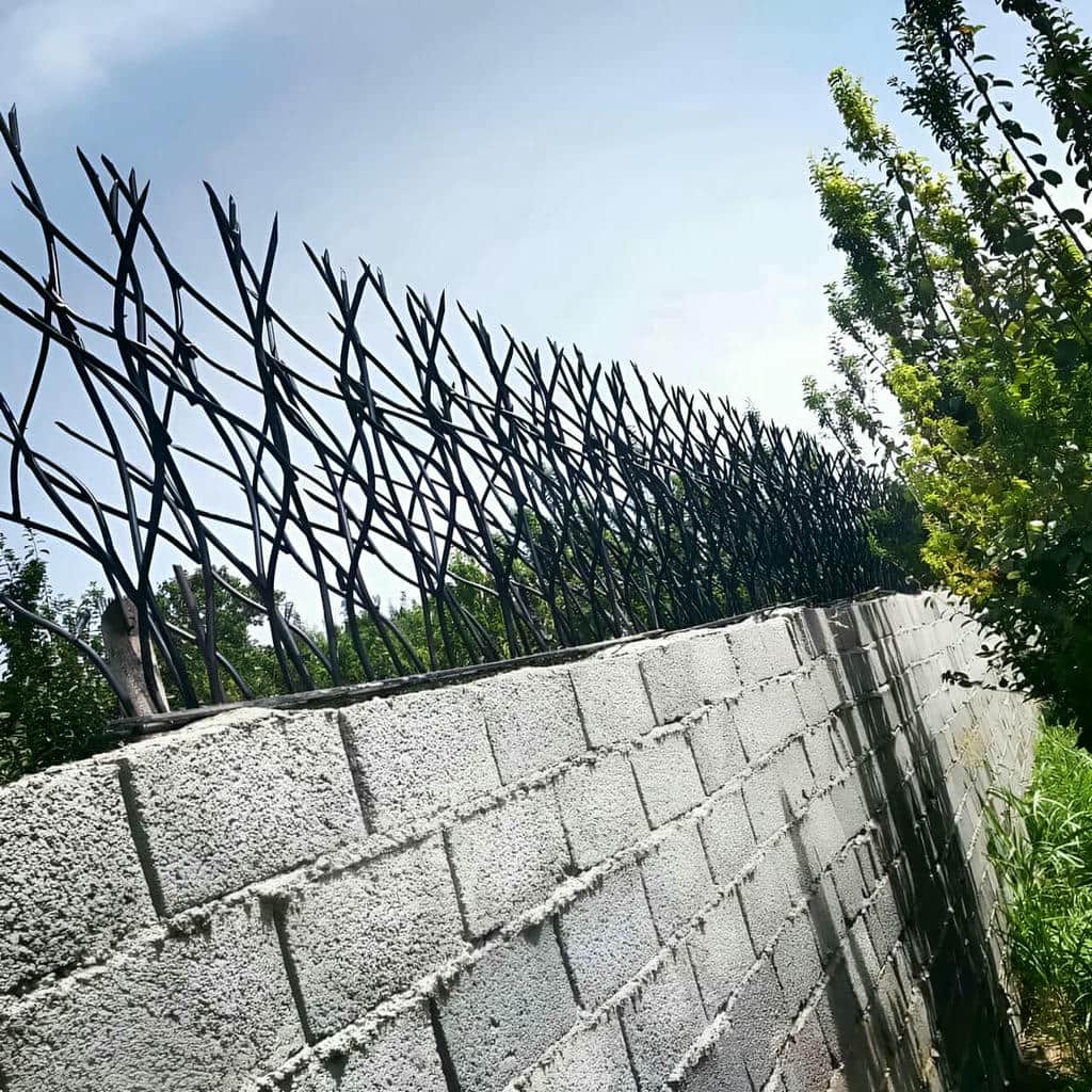 محافظ سرنیزه ای خاکستری بر دیوار آجری فرسوده