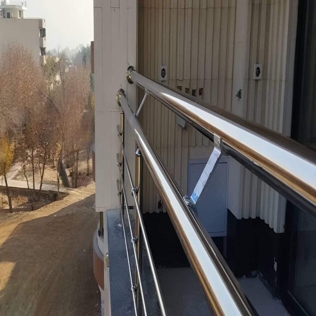 نرده بالکن استیل با میله های عمودی کنار در شیشه ای