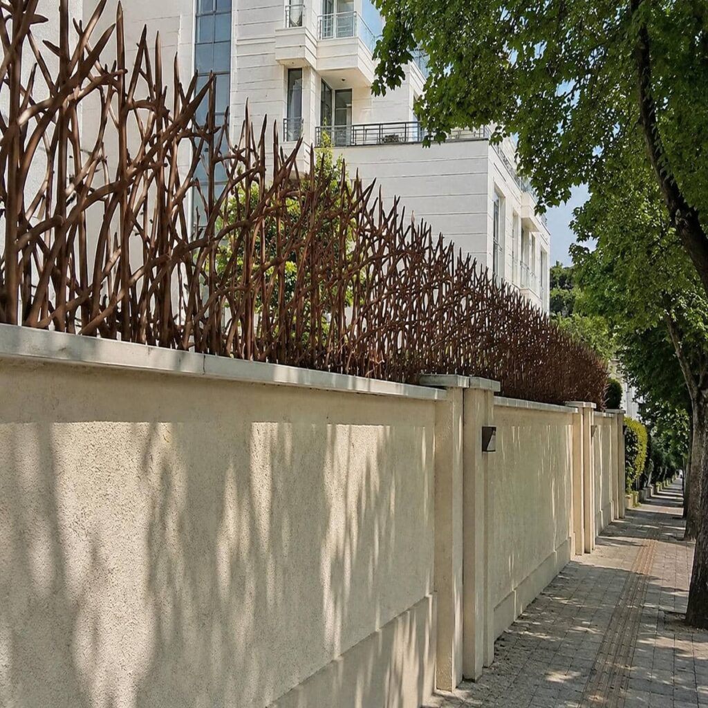 نرده سرنیزه‌ای طوسی بالای درب حیاط آجری