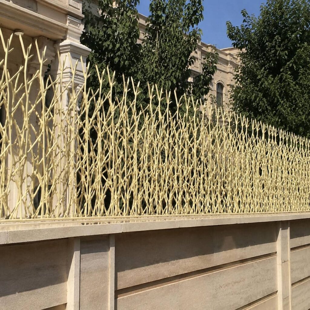 نرده سرنیزه‌ای نقره‌ای بالای دیوار ویلایی