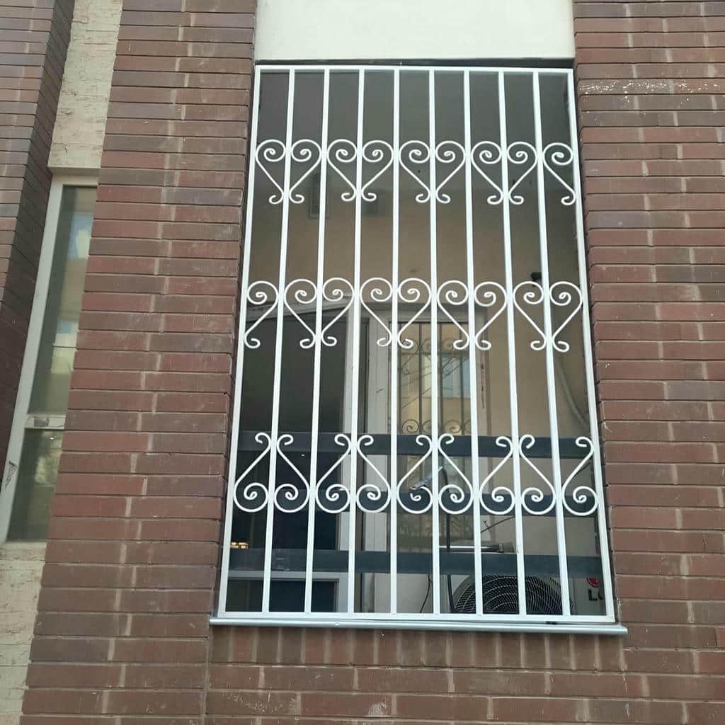 نرده لولایی طوسی با قفل جانبی روی دیوار آجری نرده لولایی طوسی با قفل جانبی روی دیوار آجری