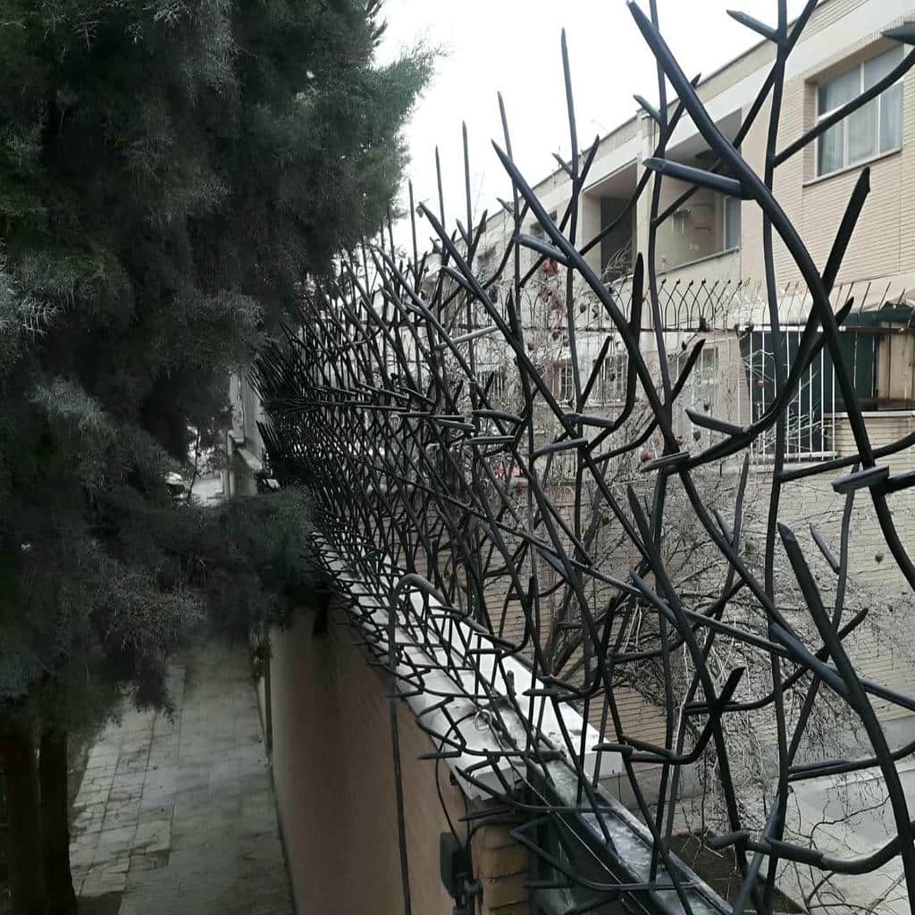 نمای نزدیک میله های نوک تیز محافظ دیواری ساختمان