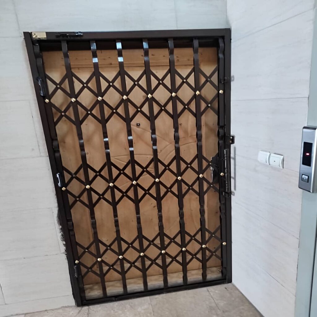 نمونه درب تاشو فلزی جمع شده کنار دیوار