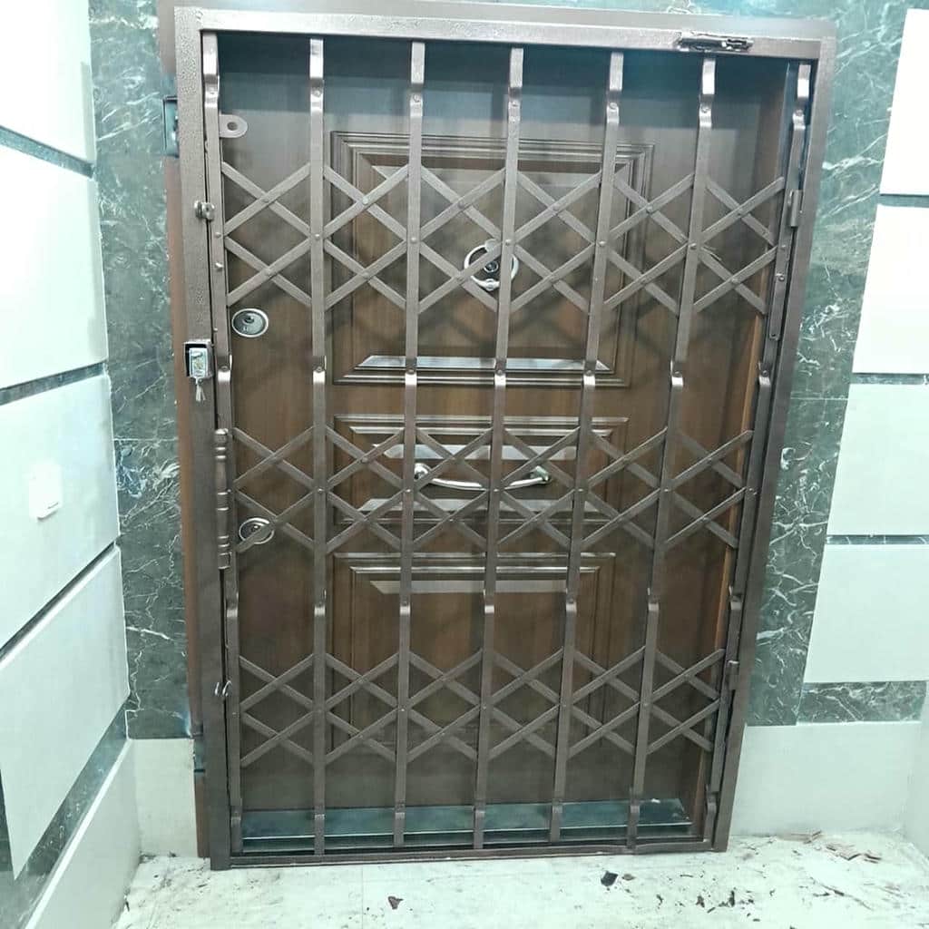 گارد آکاردئونی آهنی بسته مقابل درب چوبی واحد