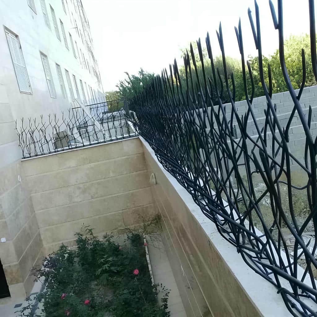 گارد دیواری آهنی با شاخههای منظم کنار درب پارکینگ گارد دیواری آهنی با شاخههای منظم کنار درب پارکینگ